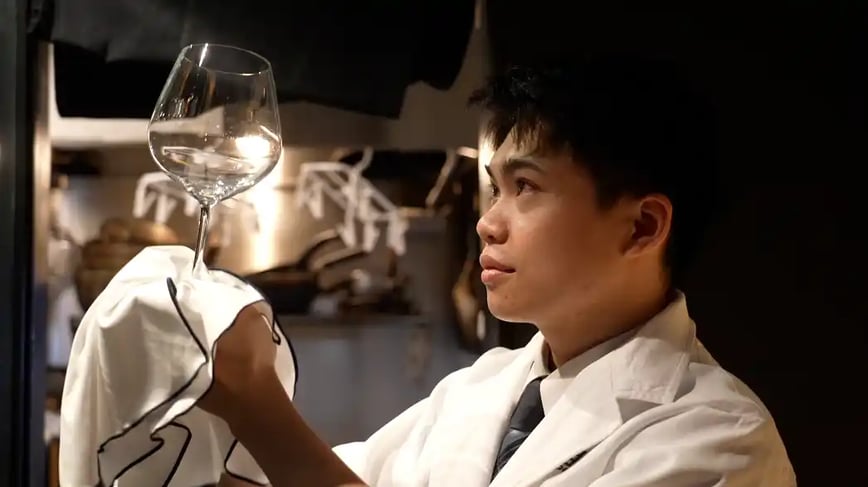 グラスを拭き上げるティエンさん の写真