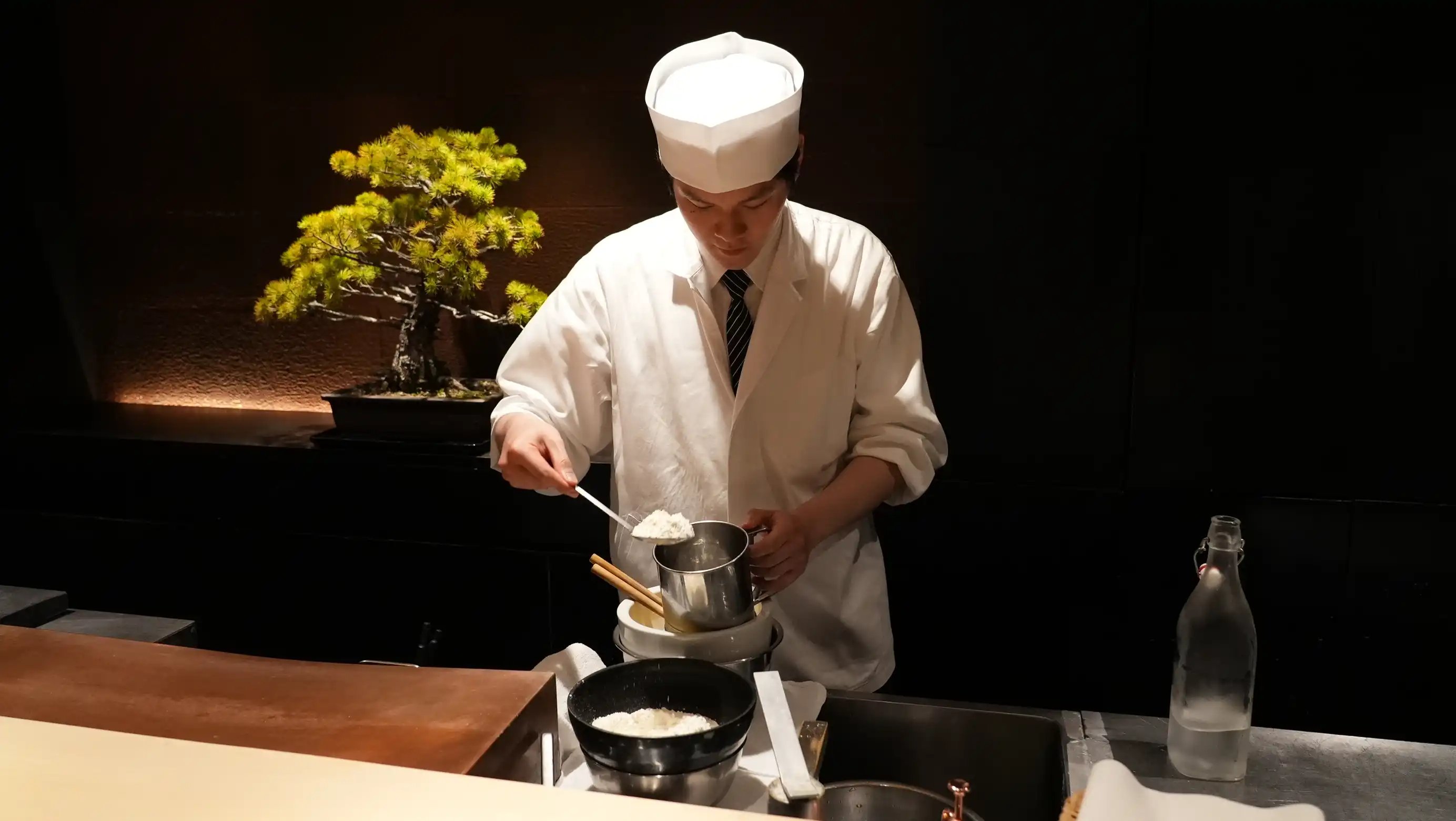 カウンターでの所作も美しいチョウさん。天ぷらを揚げる準備をしている写真