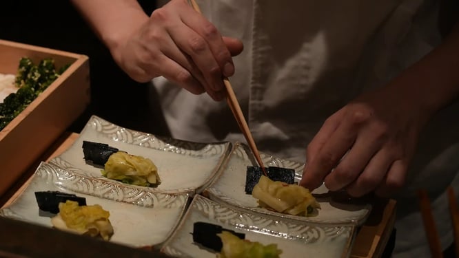 お客様に提供するお料理の盛り付けを行うトゥアンさんの写真