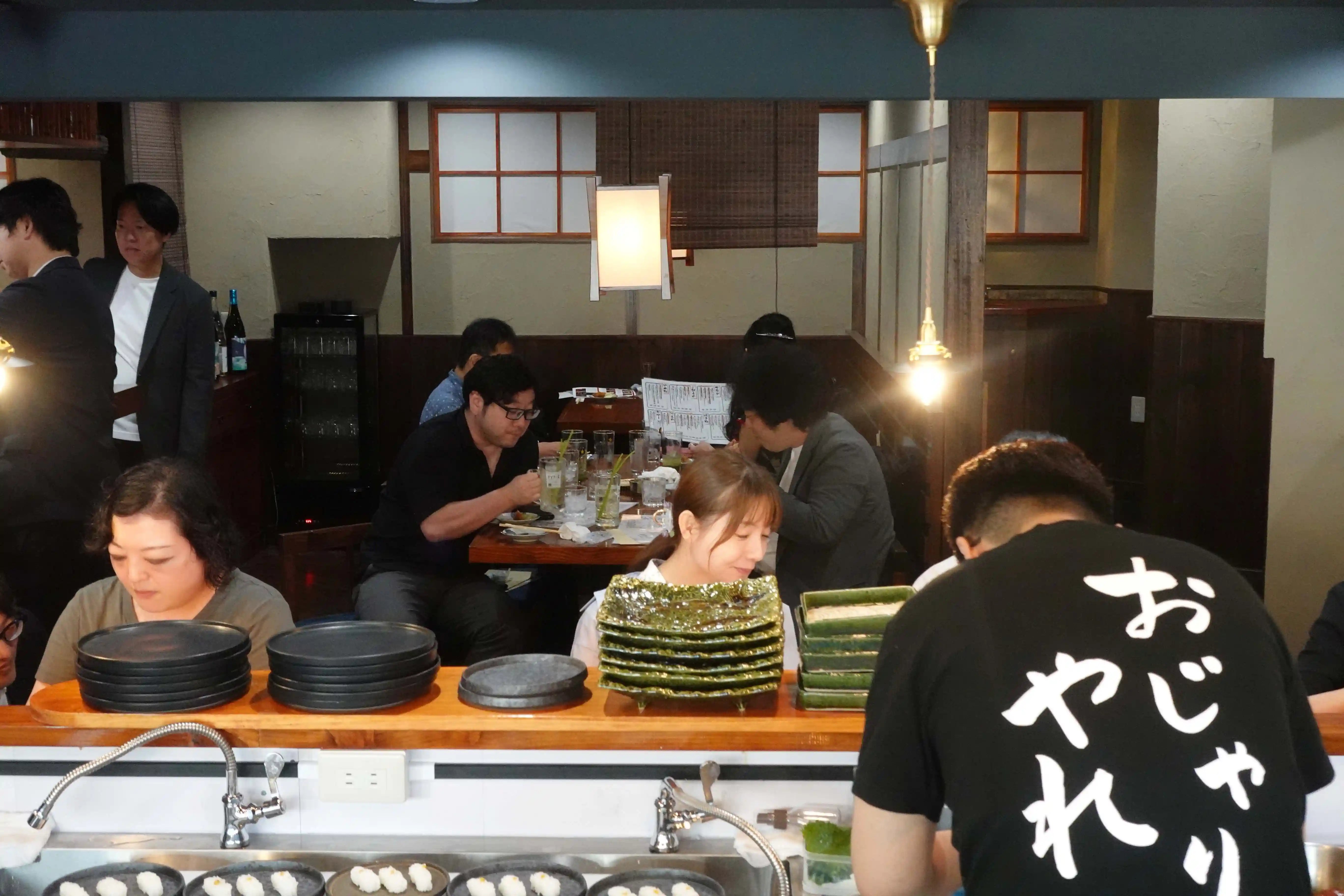 5ー店内2s-店内の入口近くにコの字型のカウンター席を設けて、調理風景をショーアップしている風景