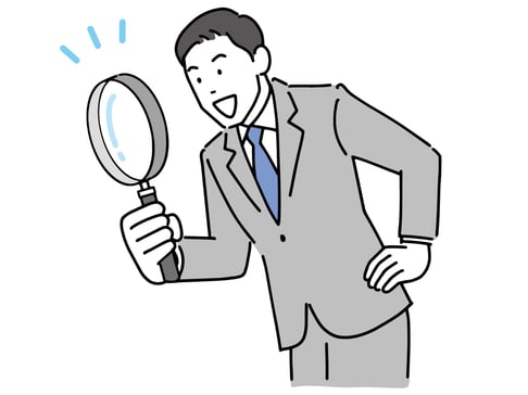 虫眼鏡で何かを覗く男性