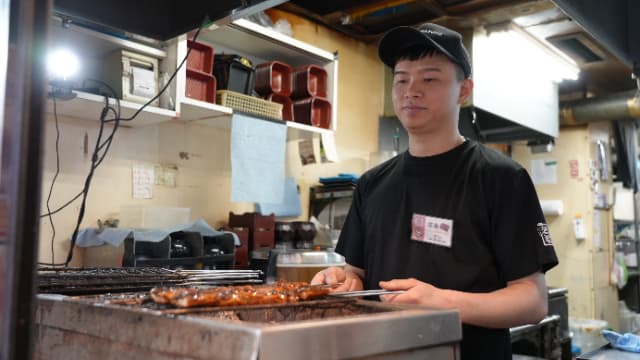 炭火でじっくりと鰻を焼く仕事中のフン店長の写真